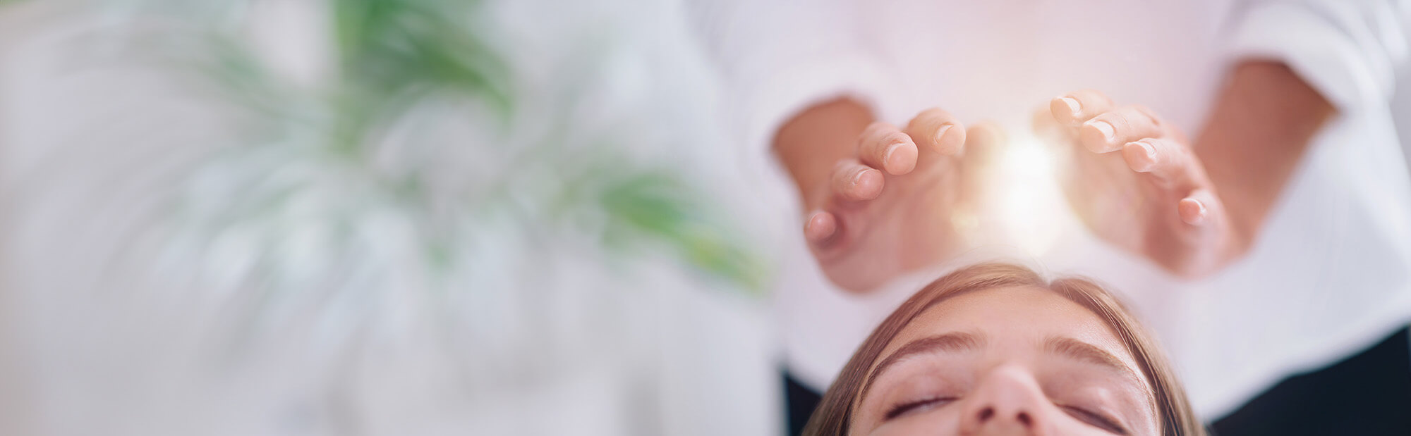 Femme recevant un soin énergétique, magnétisme, Reiki sur le front.