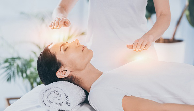Femme recevant un soin énergétique tel que le Reiki ou le magnétisme.